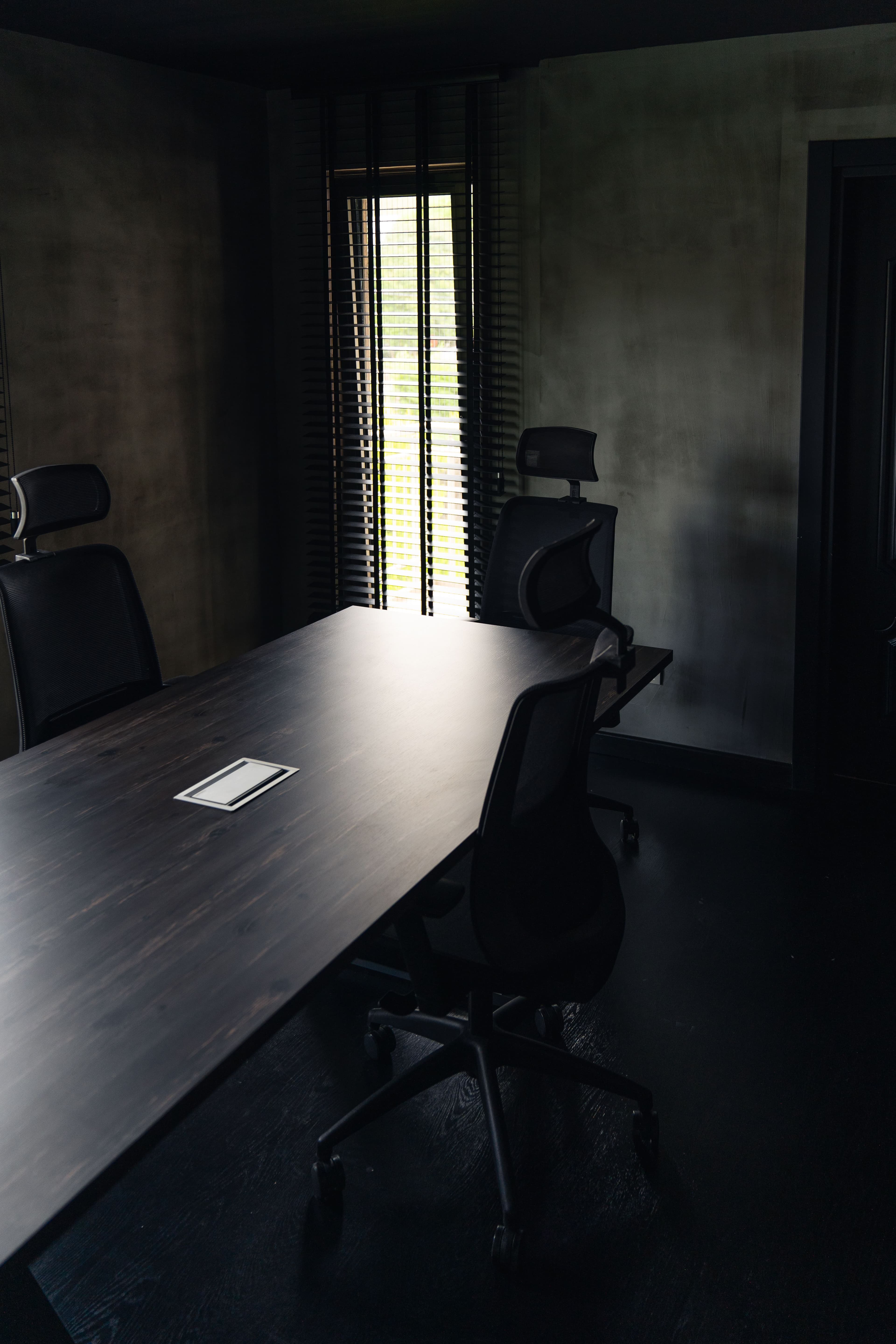 An empty meeting room lit by a single shaft of window light